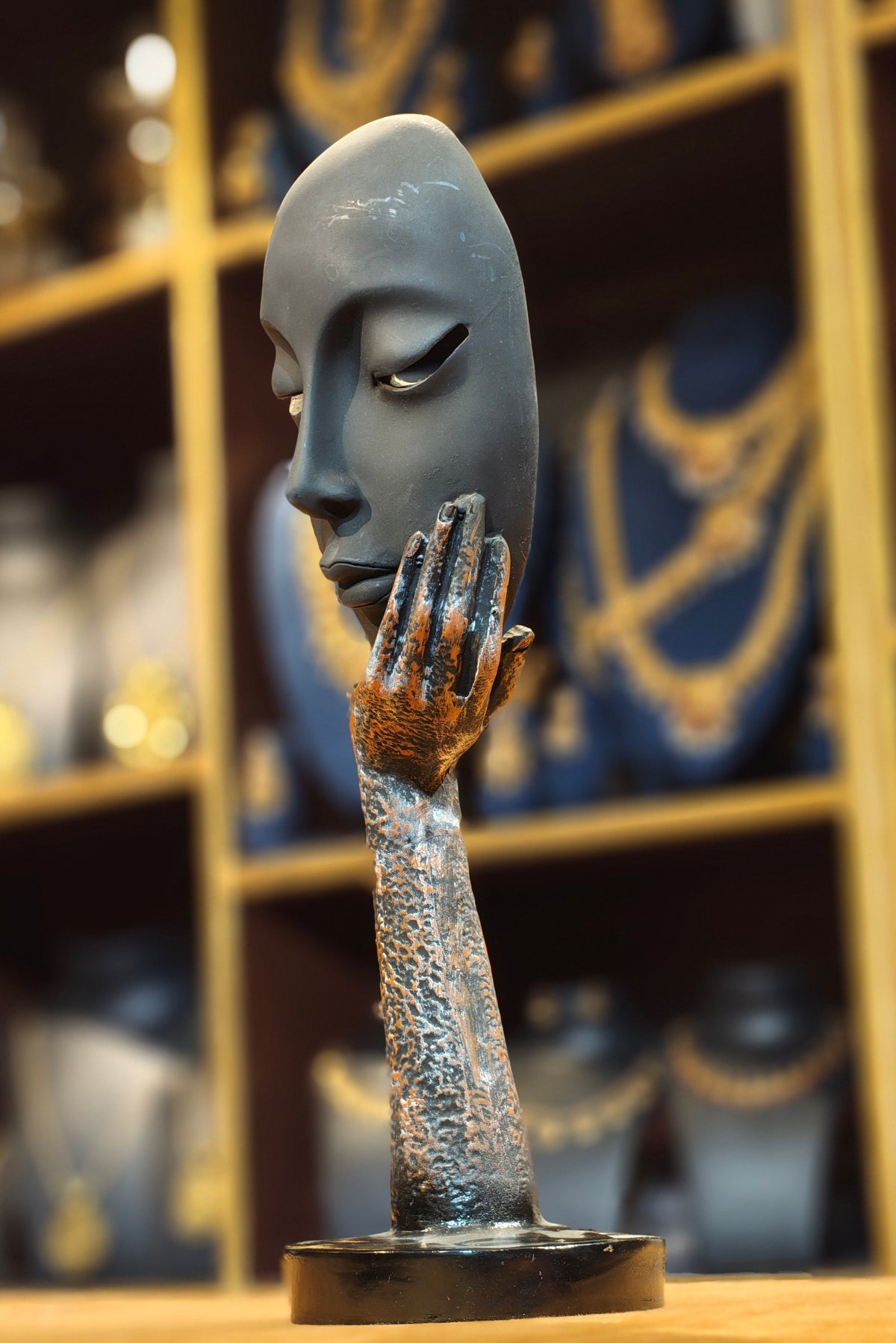 Modern Abstract Serene Face on Hand Sculpture – Matte Black & Textured Bronze Contemplation Figurine